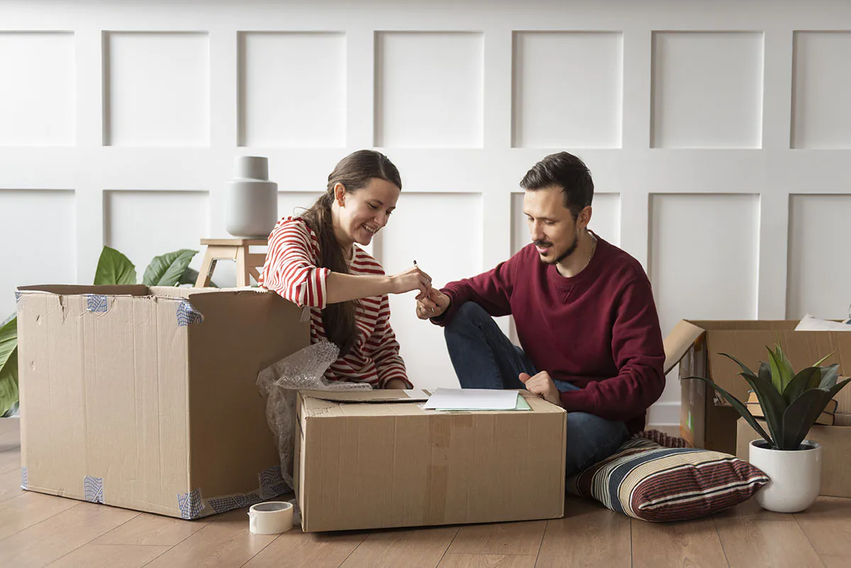 Young couple packing boxes and preparing to move to a new home.